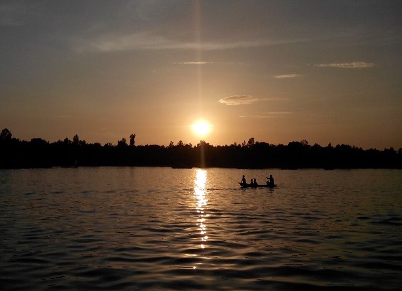 Sunset over a river in Bangladesh. The Sun sets in the west.