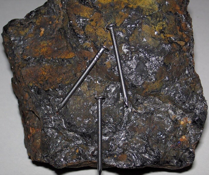 Steel nails stick to magnetite, a rock that is a natural magnet.