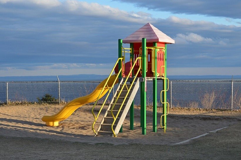 Friction between your clothes and the slide slows you down.
