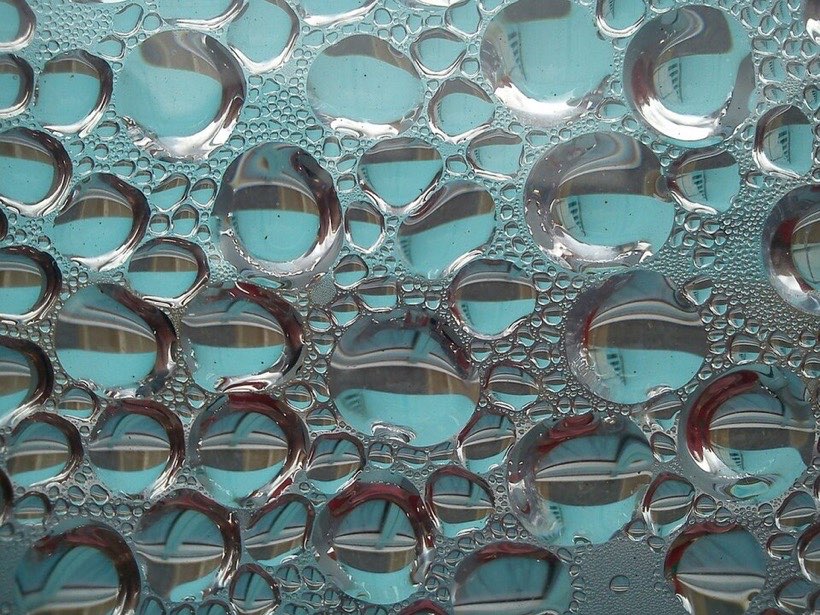 Drops of water form on the outside of a cold glass.