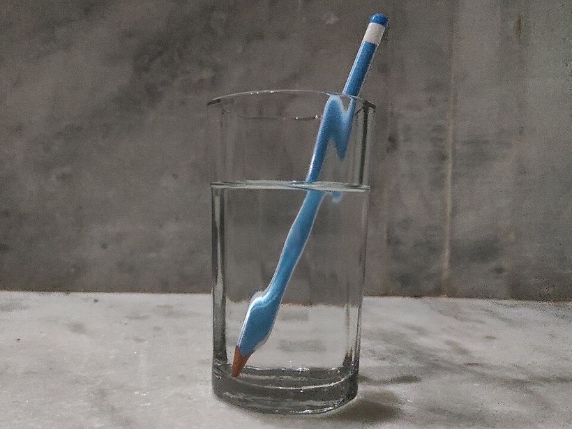 A pencil in a glass of water looks broken at the surface.