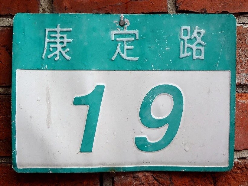 A house number plate. In many streets, even numbers are on one side and odd numbers on the other.