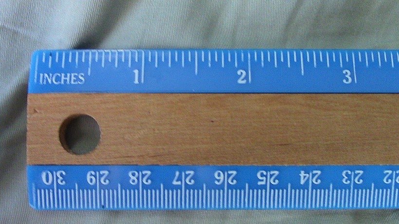 This ruler shows inches on top and centimetres below; each centimetre is split into 10 millimetres.
